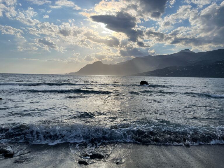 Ein Strand auf Kreta mit Blick auf das ruhige Meer bei Sonnenuntergang.